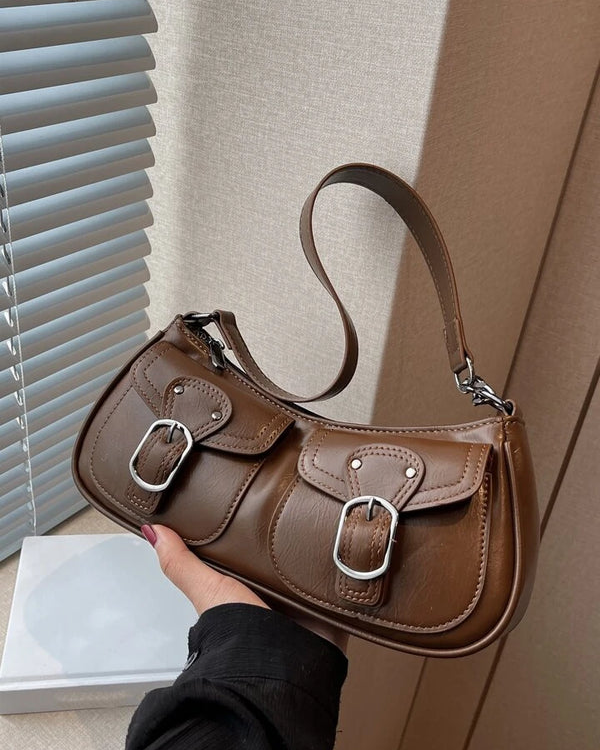 Coffee shoulder bag with front buckle pockets, silver hardware, and adjustable strap for everyday wear.