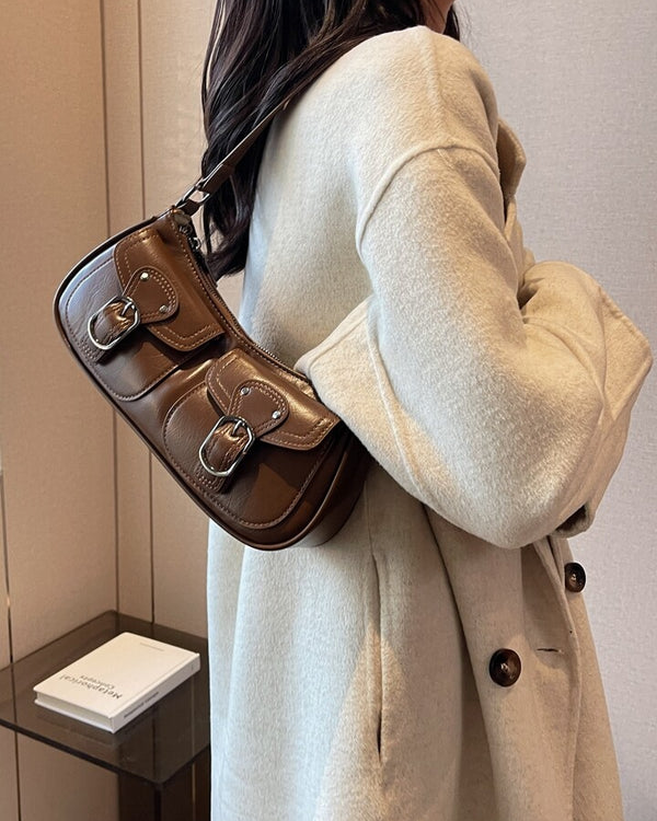 Coffee shoulder bag with front buckle pockets, silver hardware, and adjustable strap for everyday wear.