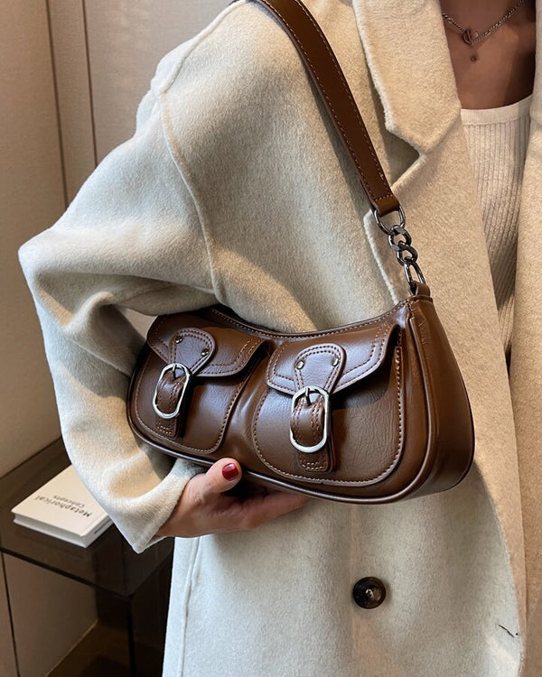 Coffee shoulder bag with front buckle pockets, silver hardware, and adjustable strap for everyday wear.