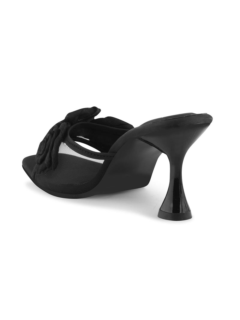JM Looks heeled mules featuring two prominent floral appliques on the vamp strap and a flared heel
 Black