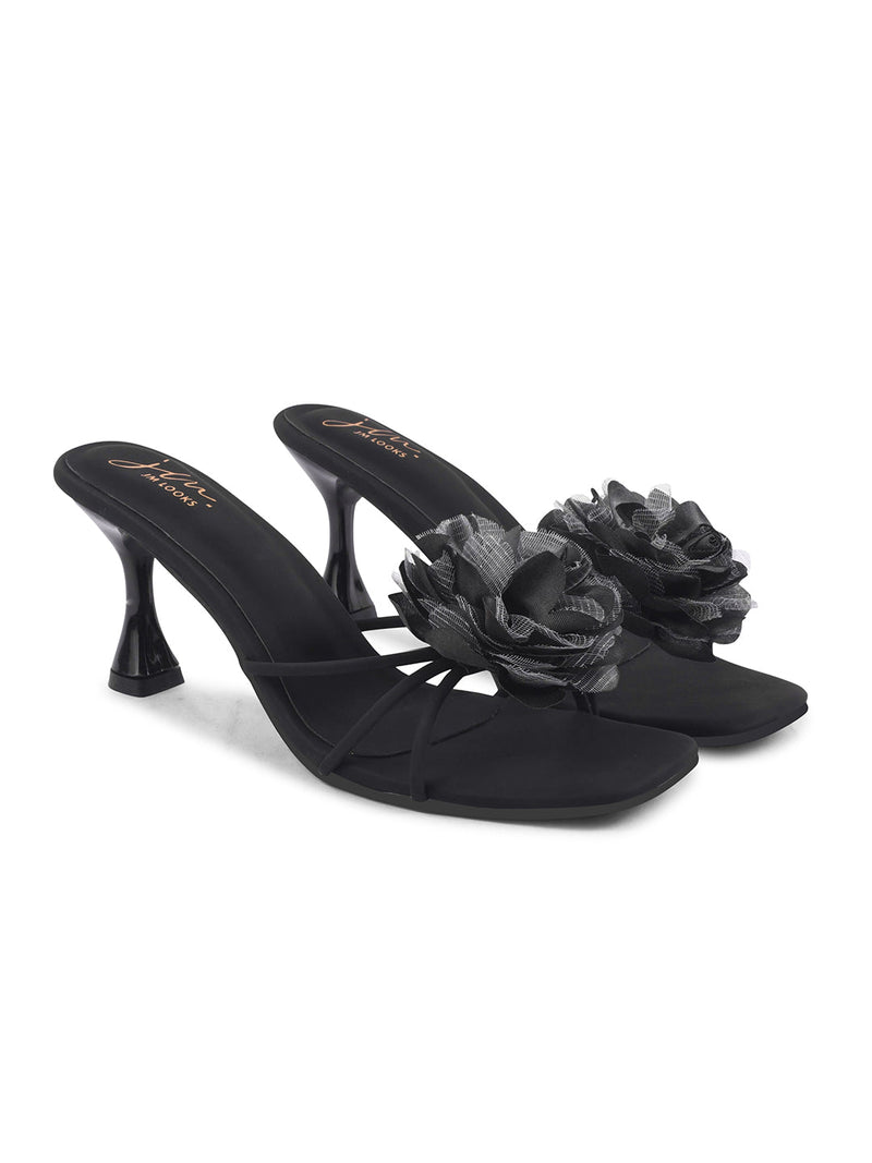 women's heeled mules featuring a large floral embellishment on the strap
 Black