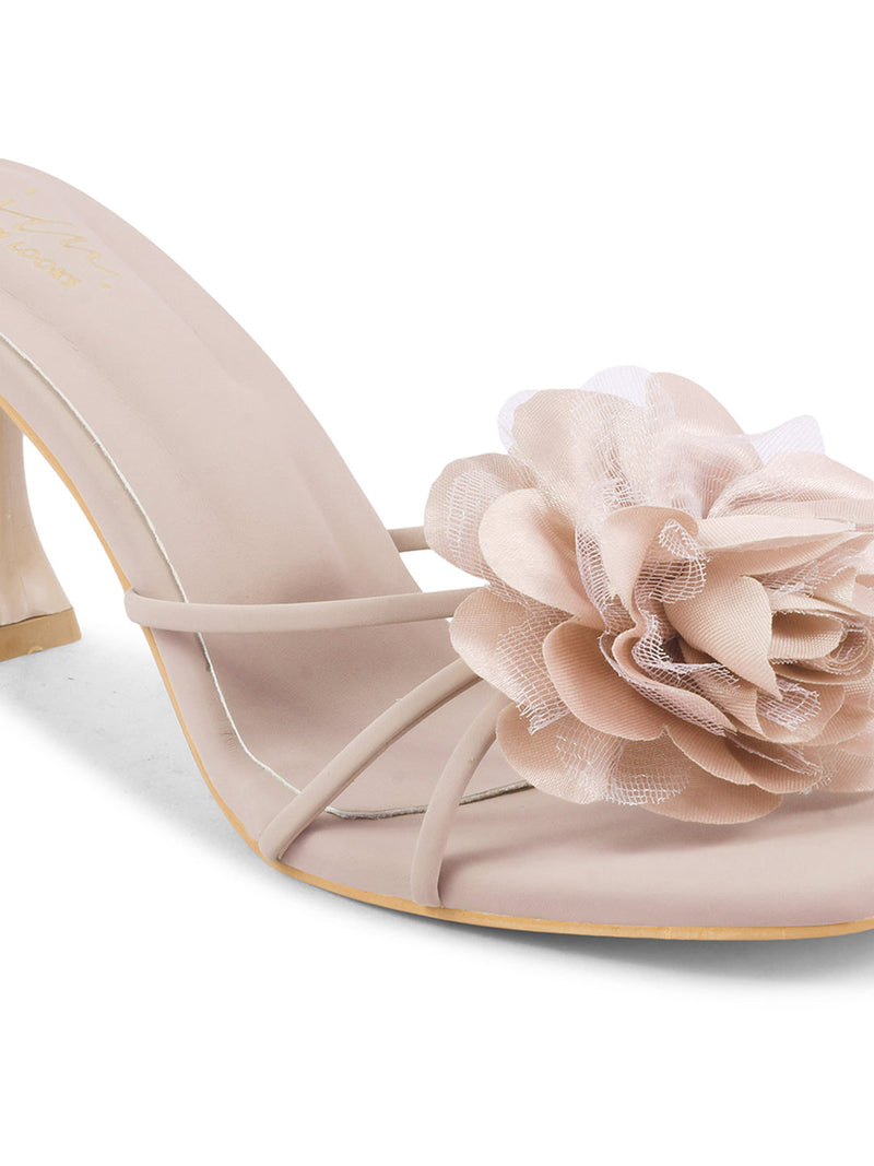 women's heeled mules featuring a large floral embellishment on the strap
 Purple