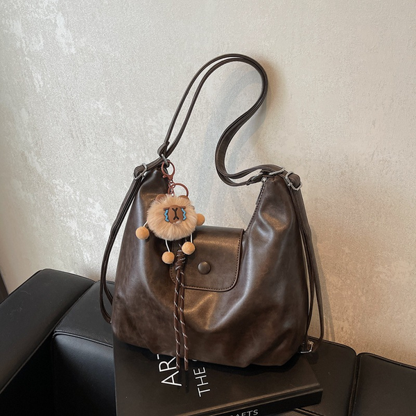 Coffee slouchy hobo shoulder bag in soft vegan leather with pom-pom keychain, versatile crossbody handbag for women