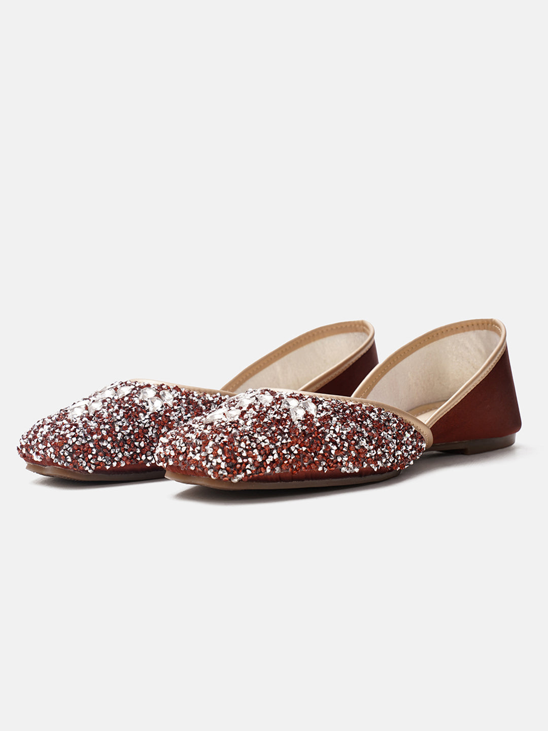 traditional juttis heavily embellished with sequins and large stone details in a floral pattern at the toe
 Copper