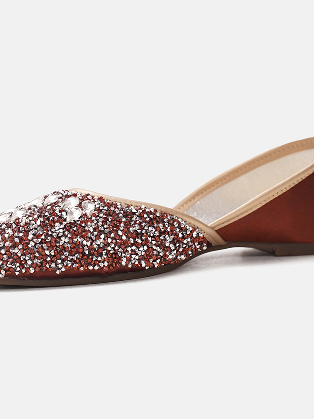 traditional juttis heavily embellished with sequins and large stone details in a floral pattern at the toe
 Copper