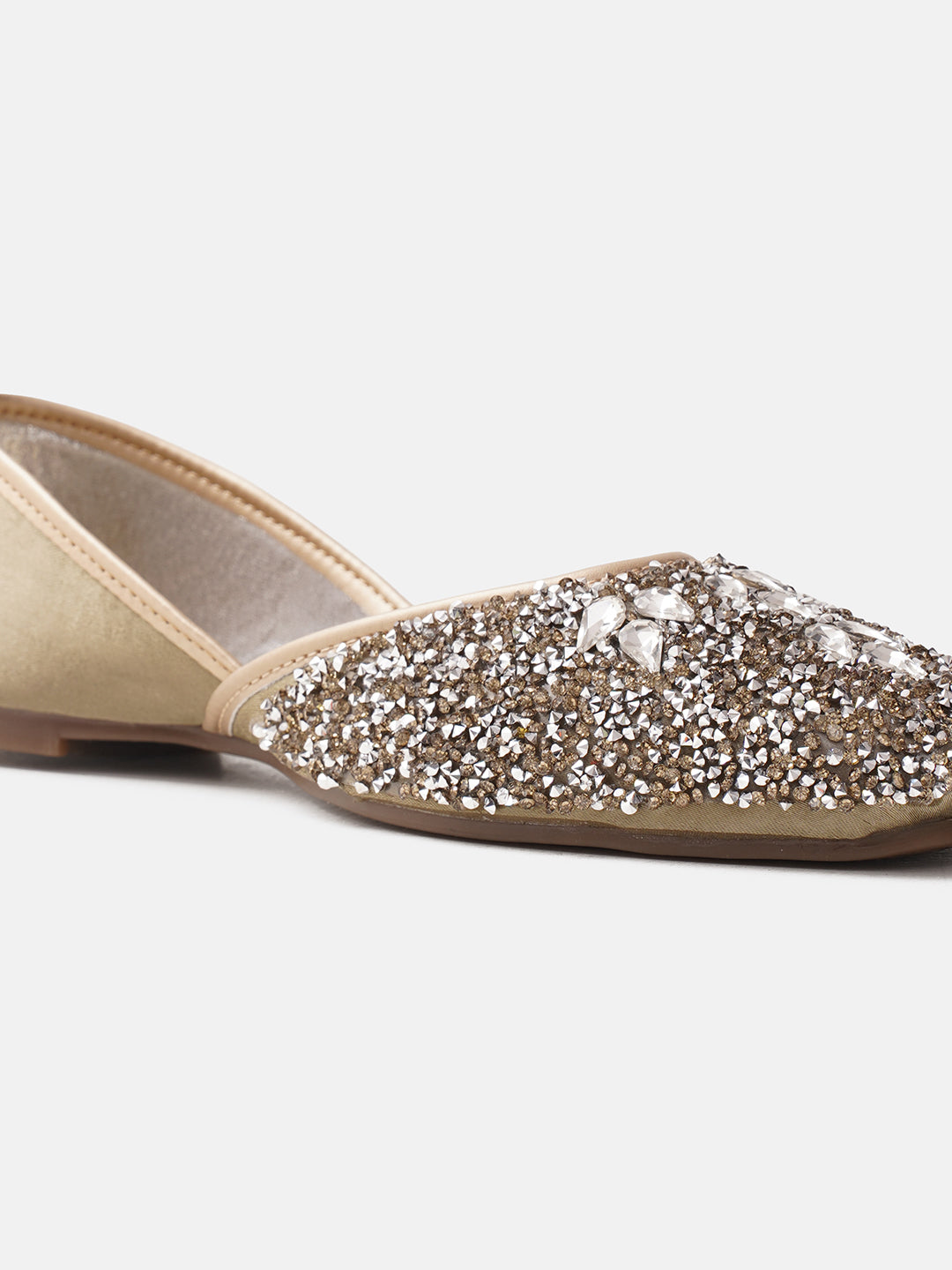traditional juttis heavily embellished with sequins and large stone details in a floral pattern at the toe
 Green