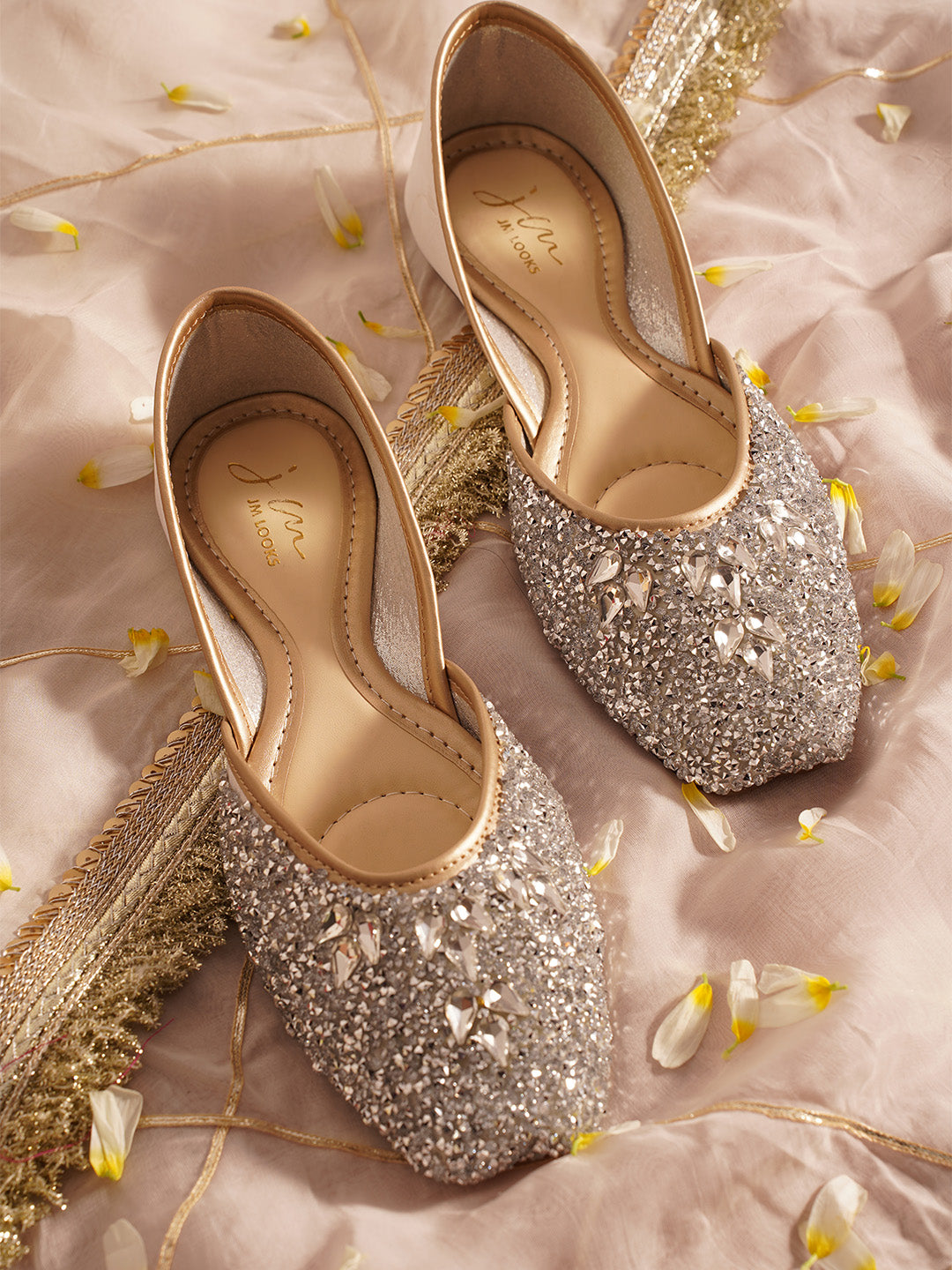 traditional juttis heavily embellished with sequins and large stone details in a floral pattern at the toe
 White