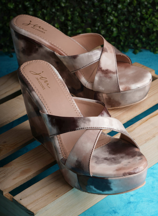 Platform wedge heels in cream brown watercolor print with criss cross straps, open toe slip-on design.
