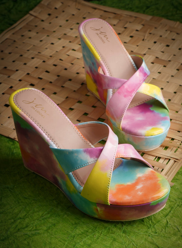 Platform wedge heels in pink watercolor print with criss cross straps, open toe slip-on design.