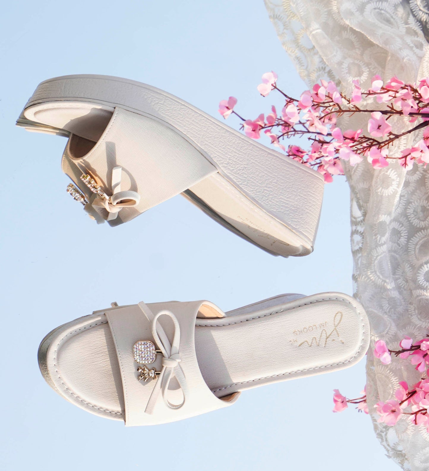 Jm Looks wedge slides with a decorative bow on the strap
 Cream