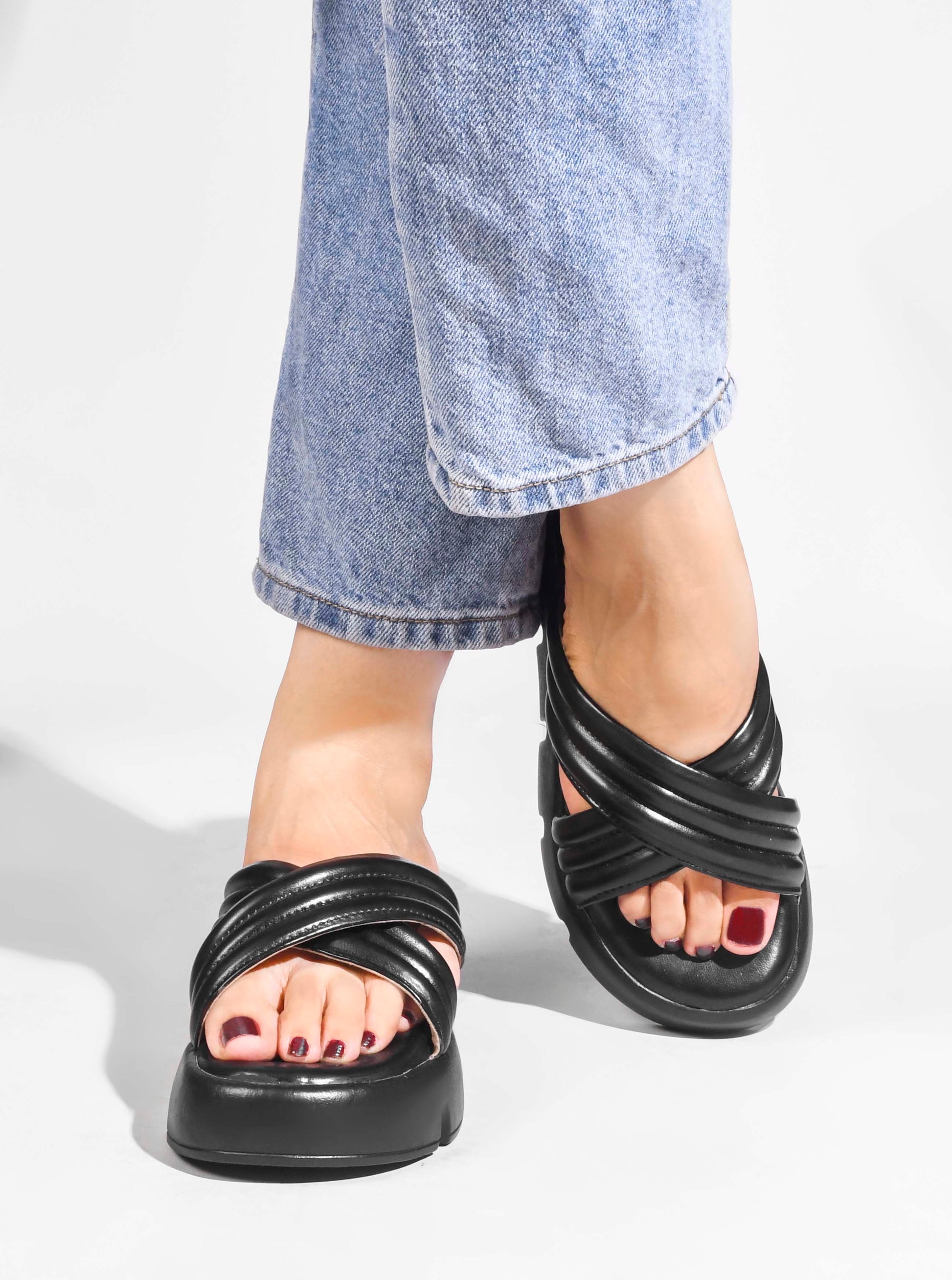 women's platform slides with wide, padded crisscross straps and a chunky lug sole
 Black