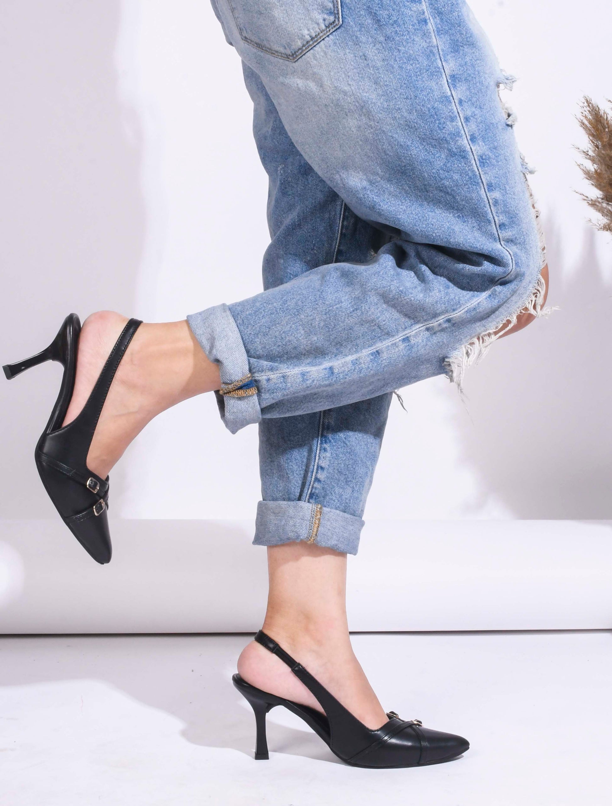 A pointed-toe slingback heel with strap and buckle details on the vamp and an adjustable strap
 Black