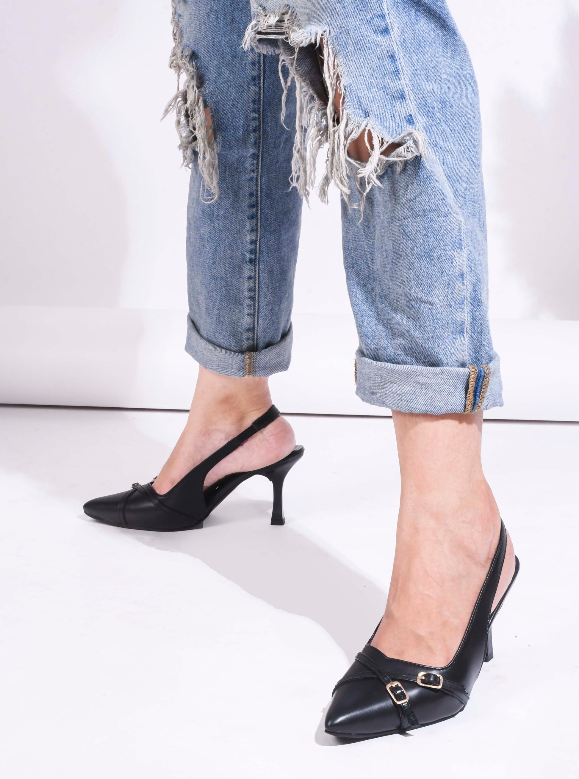 A pointed-toe slingback heel with strap and buckle details on the vamp and an adjustable strap
 Black