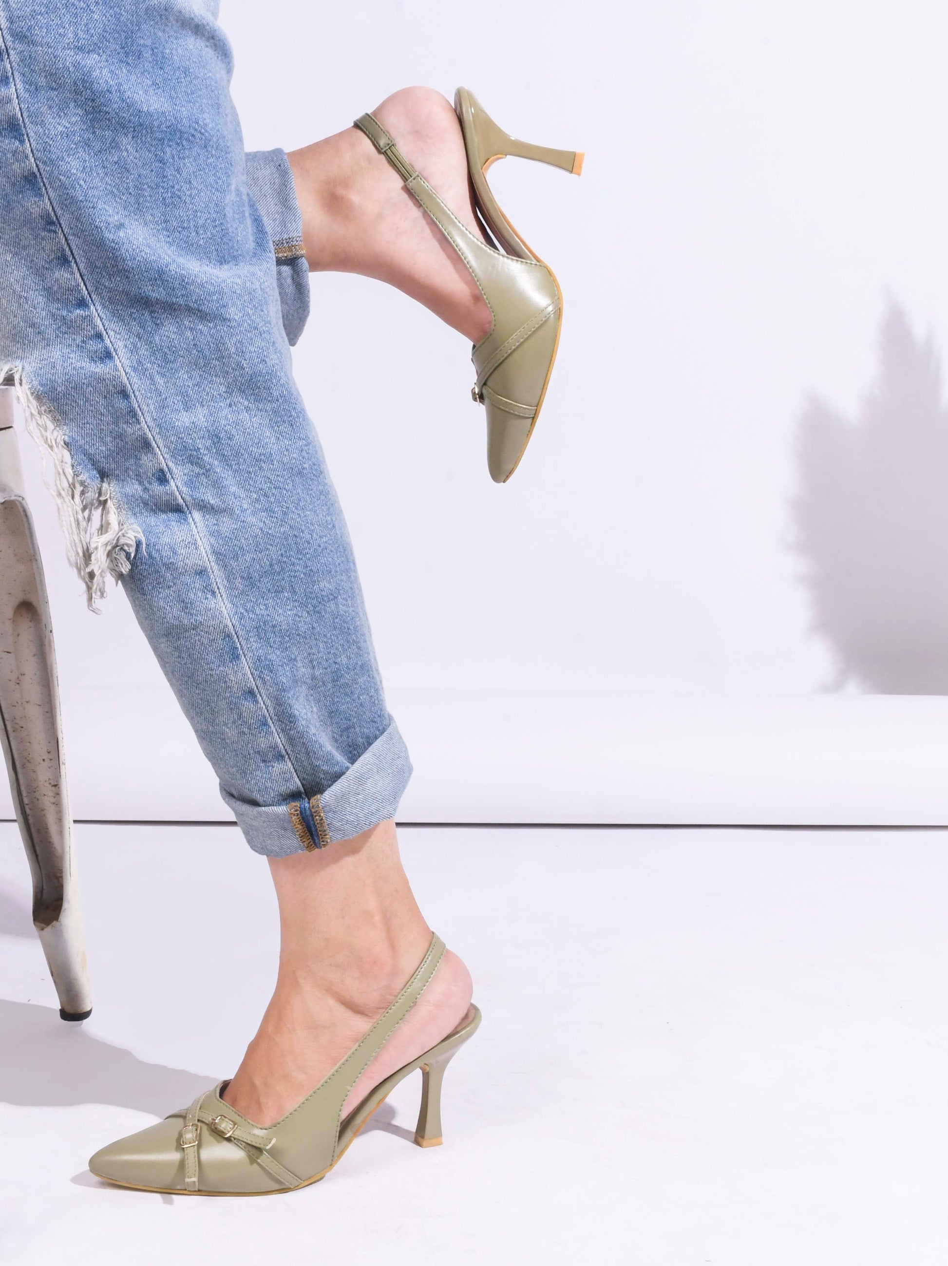 A pointed-toe slingback heel with strap and buckle details on the vamp and an adjustable strap
 Green