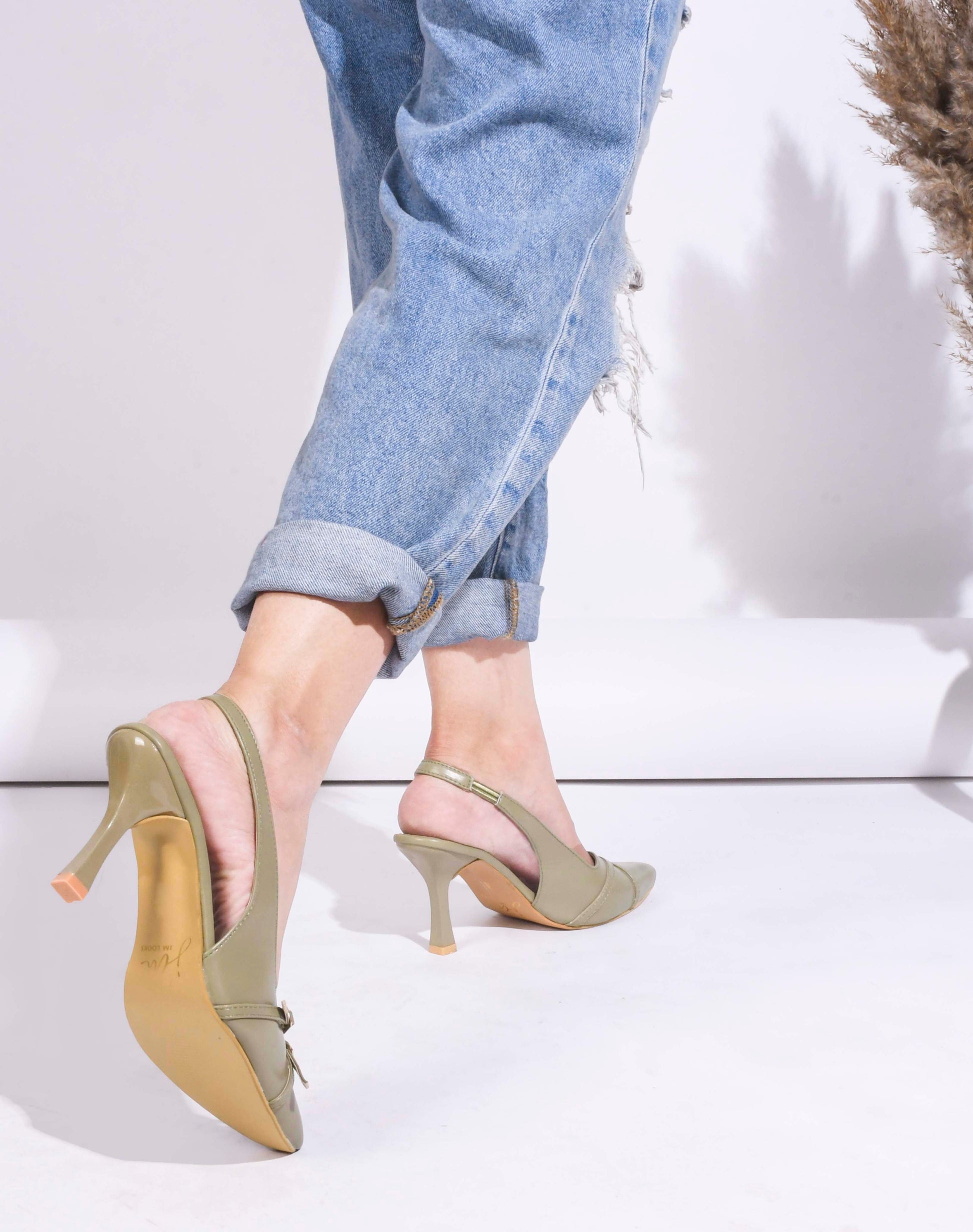 A pointed-toe slingback heel with strap and buckle details on the vamp and an adjustable strap
 Green