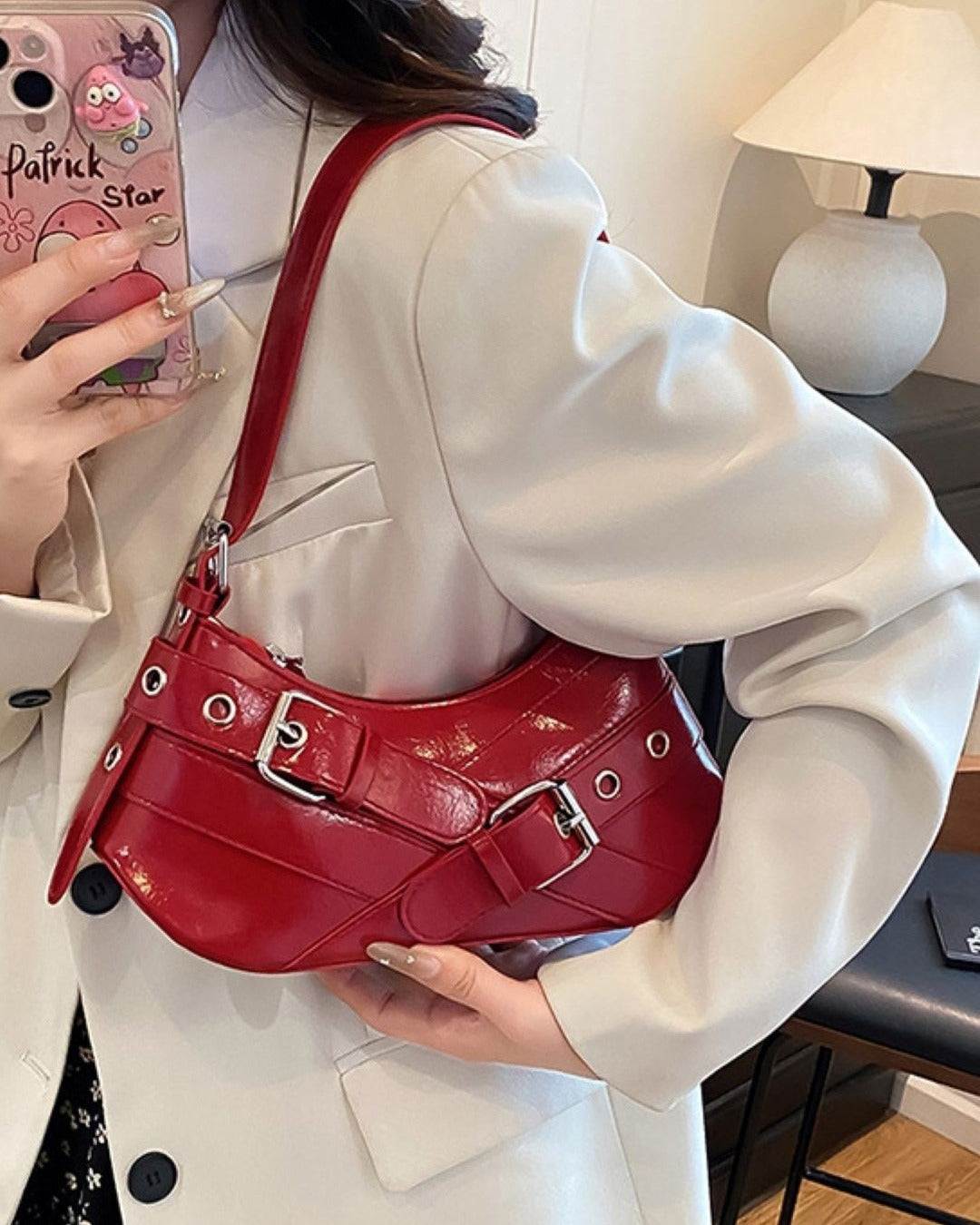 Hobo shoulder bag in red featuring double buckle straps, silver hardware, and an adjustable strap design.