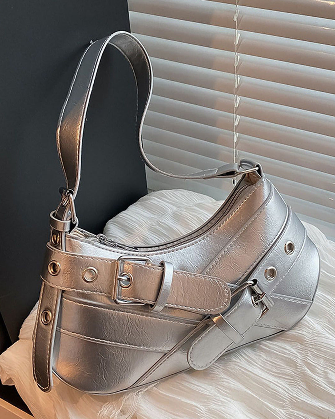 Hobo shoulder bag in silver featuring double buckle straps, silver hardware, and an adjustable strap design.