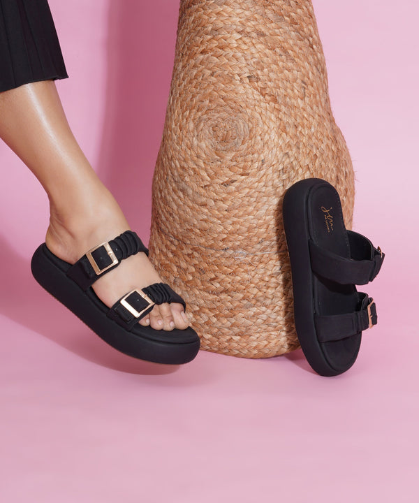 Platform sandals for women in black with ruched dual straps, gold buckles and thick cushioned footbed