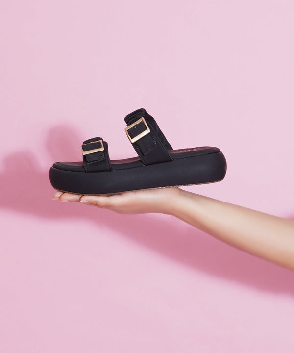 Platform sandals for women in black with ruched dual straps, gold buckles and thick cushioned footbed