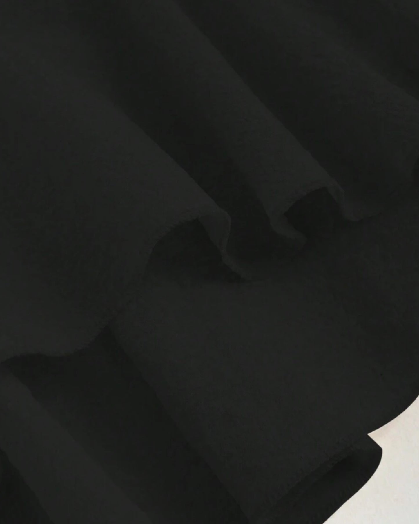 Ruffle trim blouse with sweetheart neckline in black, featuring smocked bodice, flutter sleeves, flared peplum hem
