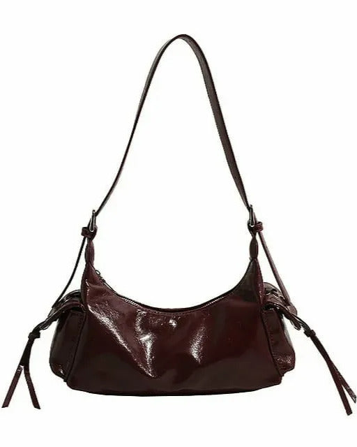 Brown glossy hobo shoulder bag with adjustable strap, side lace-up pockets, and sleek zip closure design