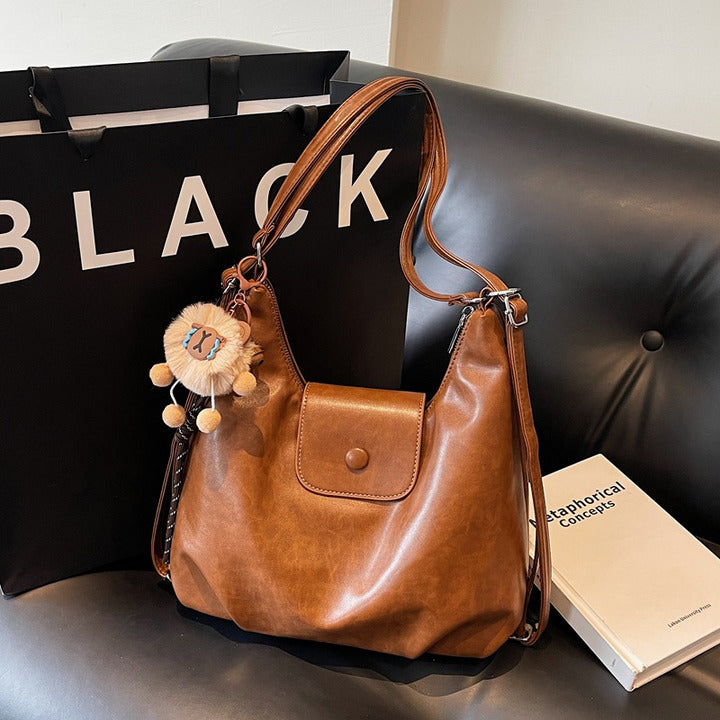 Coffee slouchy hobo shoulder bag in soft vegan leather with pom-pom keychain, versatile crossbody handbag for women