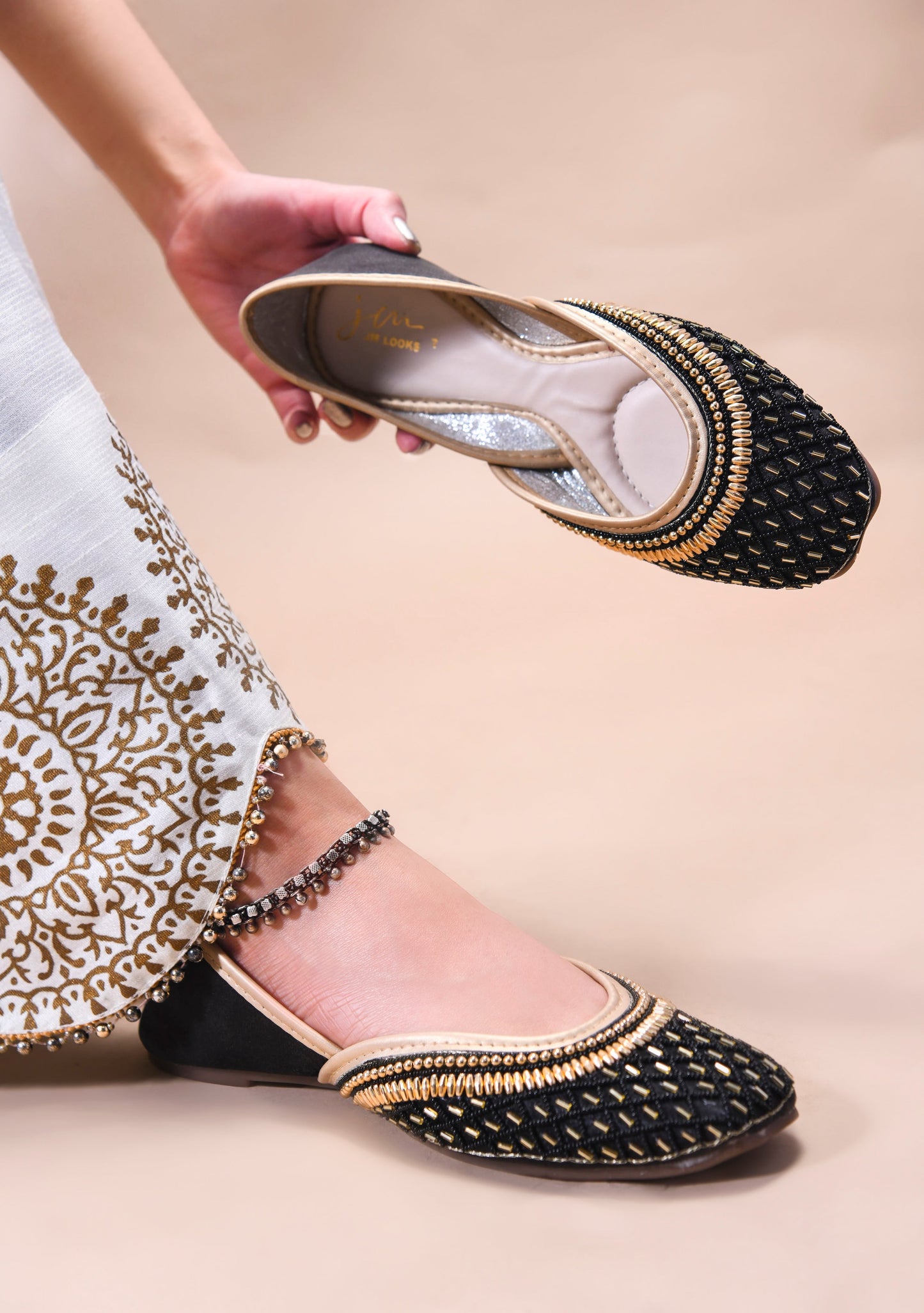 traditional juttis with intricate beaded work in a geometric pattern on the upper
 Black