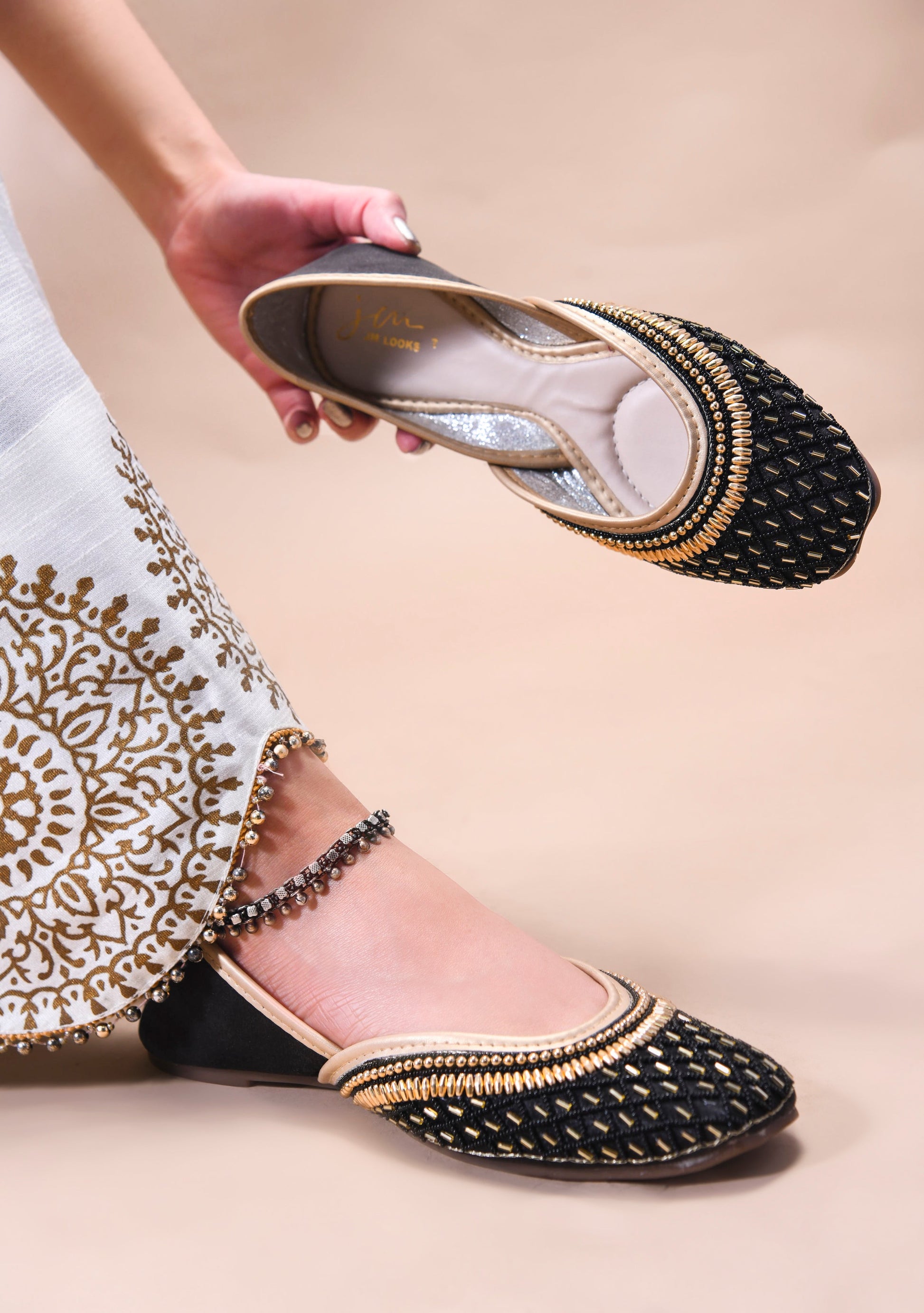 traditional juttis with intricate beaded work in a geometric pattern on the upper
 Black