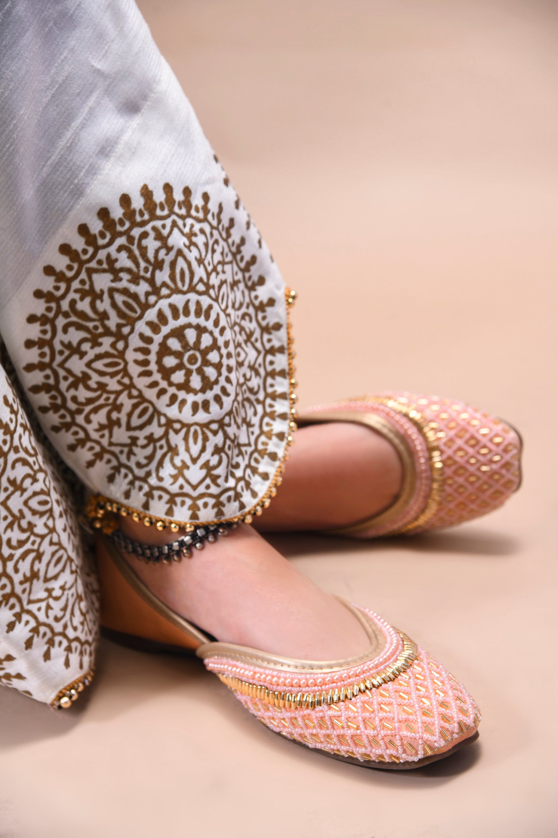 traditional juttis with intricate beaded work in a geometric pattern on the upper
 Peach