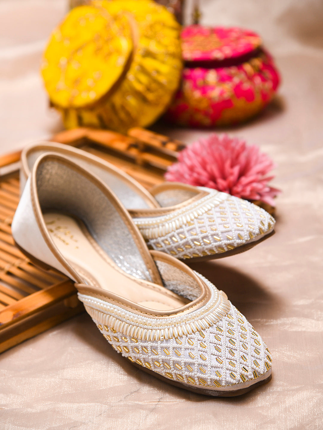 traditional juttis with intricate beaded work in a geometric pattern on the upper
 White