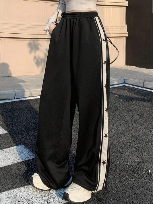 Wide leg track pants for women in black featuring white side stripe with black star print