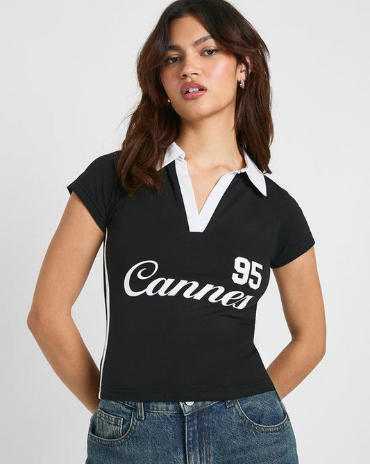 Black collared polo t-shirt for women featuring white contrast collar, side stripe, and printed graphic detailing