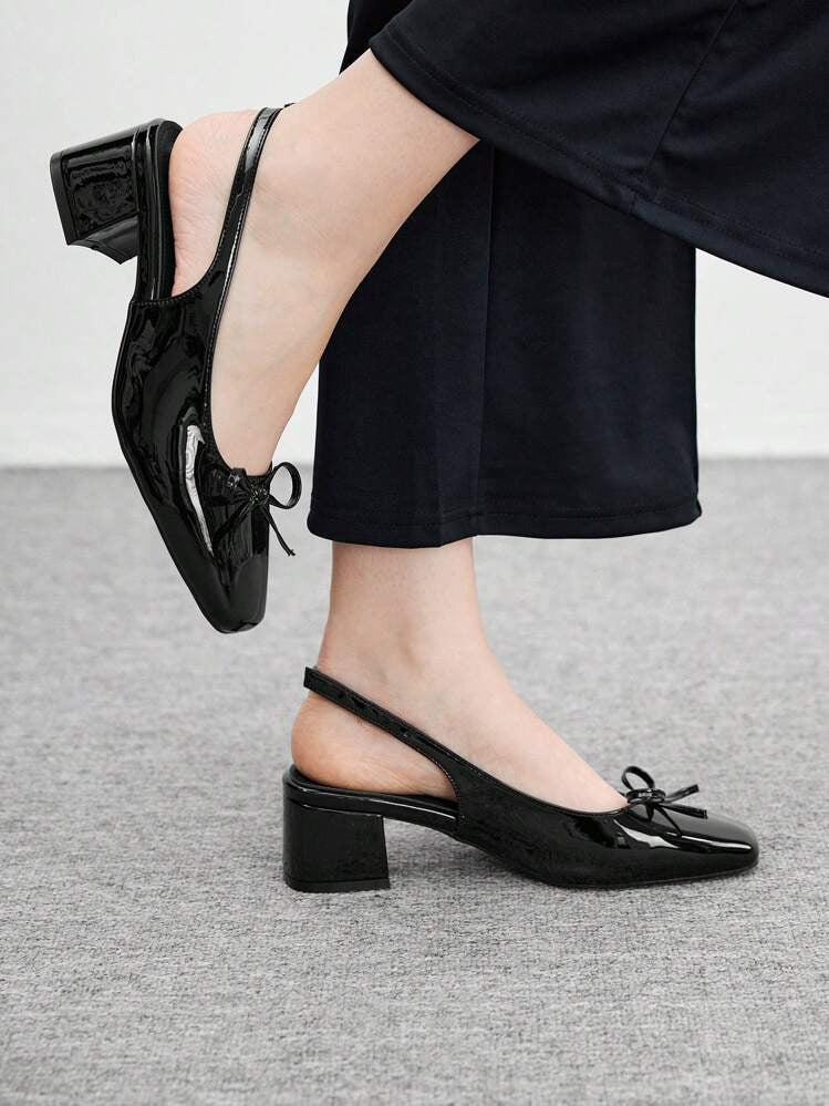 Women's black patent Mary Jane slingback block heels with bow detail, square toe and chunky heel.