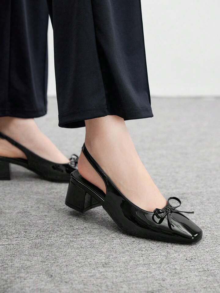 Women's black patent Mary Jane slingback block heels with bow detail, square toe and chunky heel.
