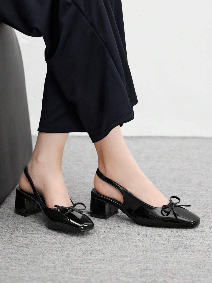 Women's black patent Mary Jane slingback block heels with bow detail, square toe and chunky heel.